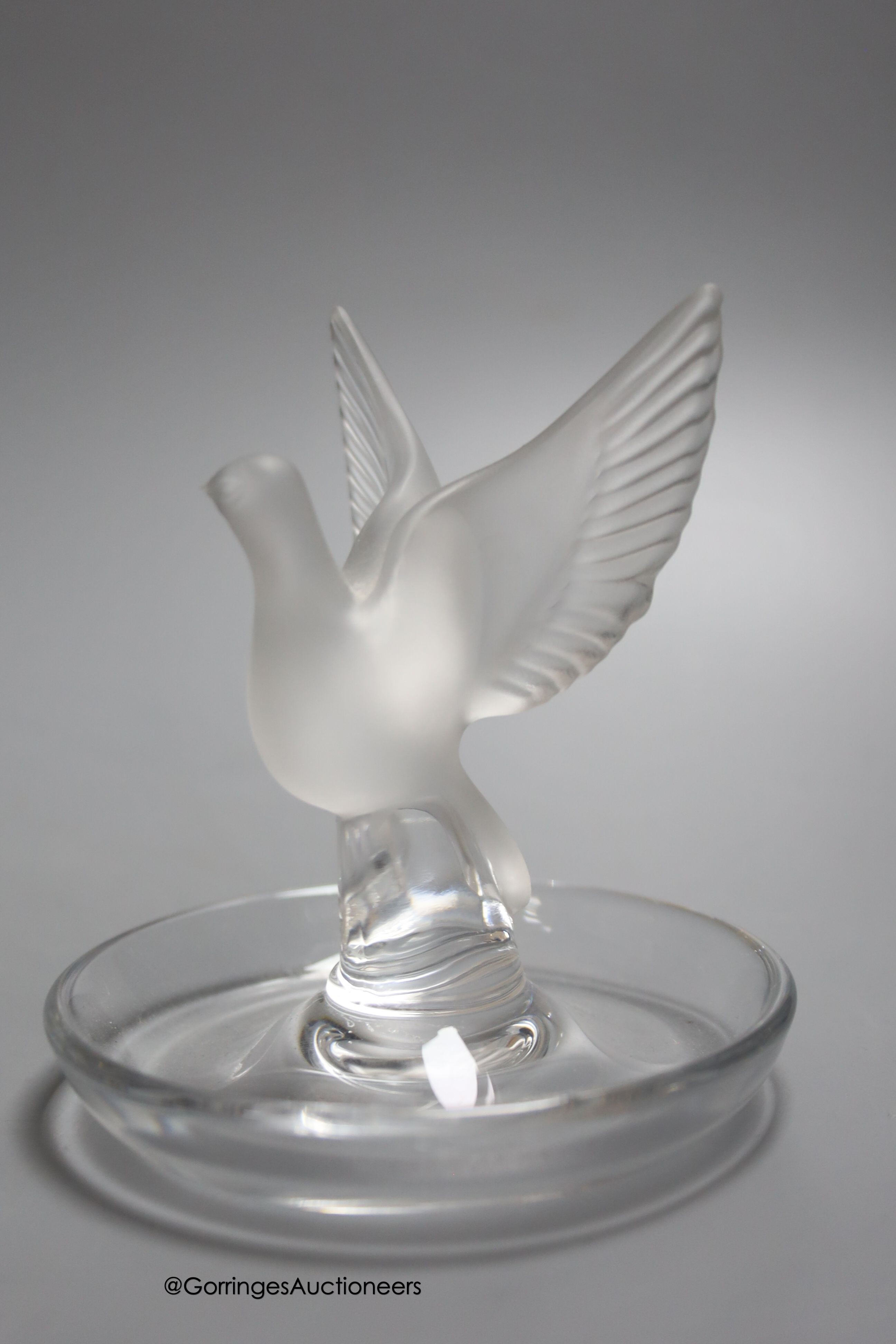 Two Lalique ashtrays mounted with birds, etched signatures to bases, and a Lalique style frosted glass bird paperweight